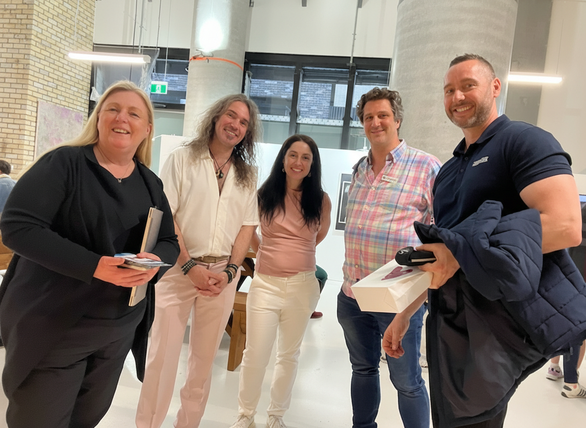 Group of five smiling people standing indoors in a modern building.