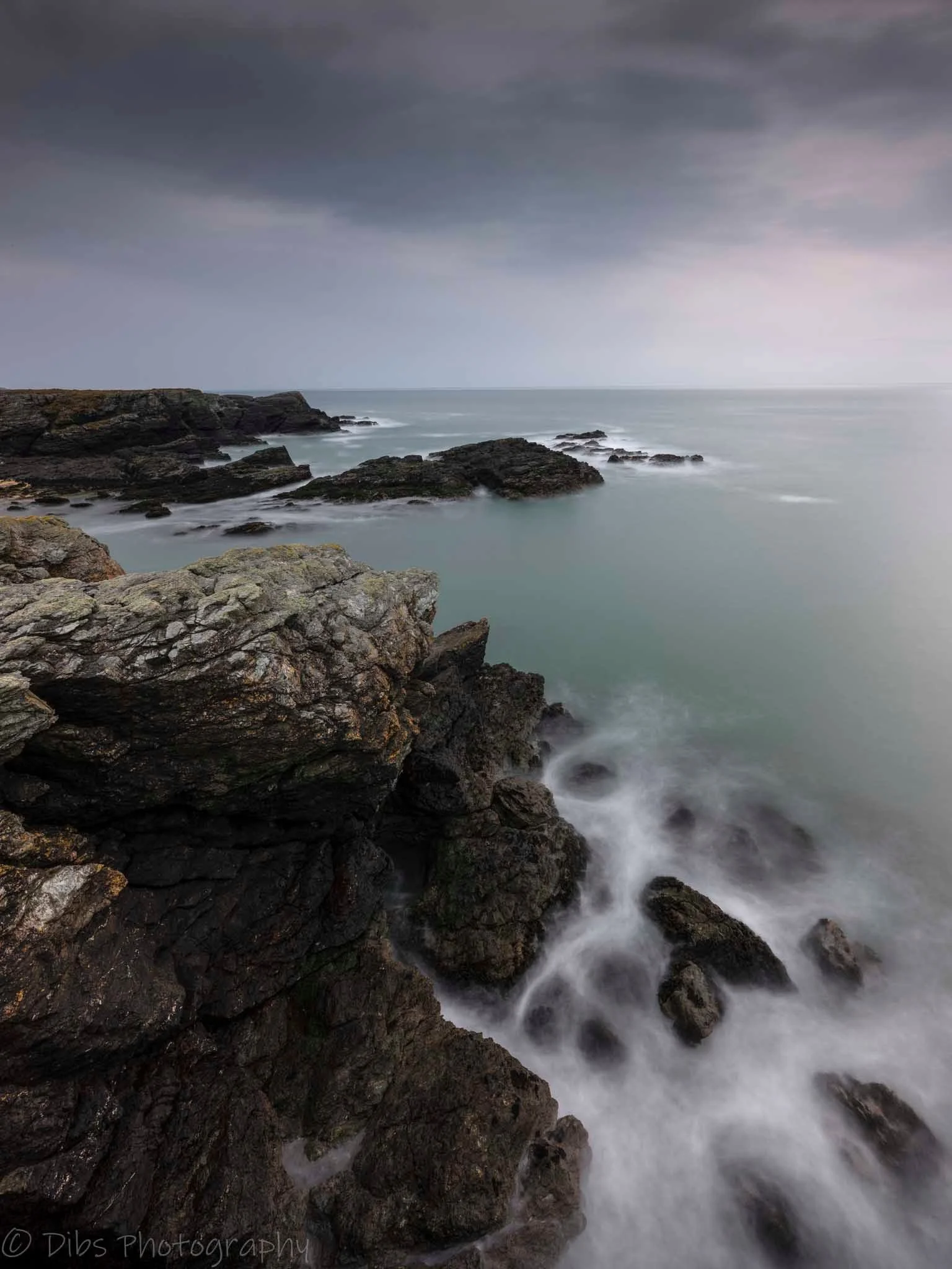 Long-exposure seascape over rocks on the Anglesey coast