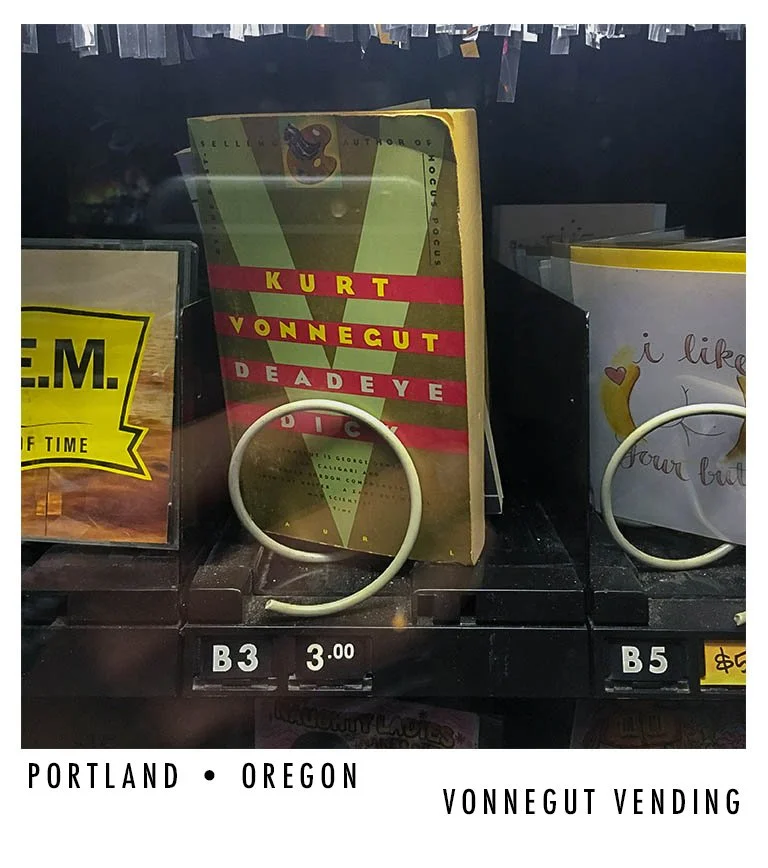 A book titled 'DEAD EYE' by Kurt Vonnegut is displayed on a vending machine shelf in Portland, Oregon.
