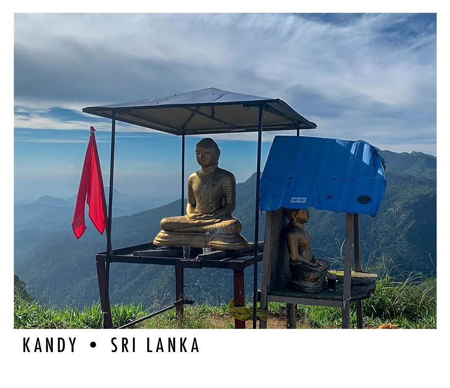 Two Buddha statues on a mountain with scenic valley views, a red flag, and a blue tarp in Sri Lanka.