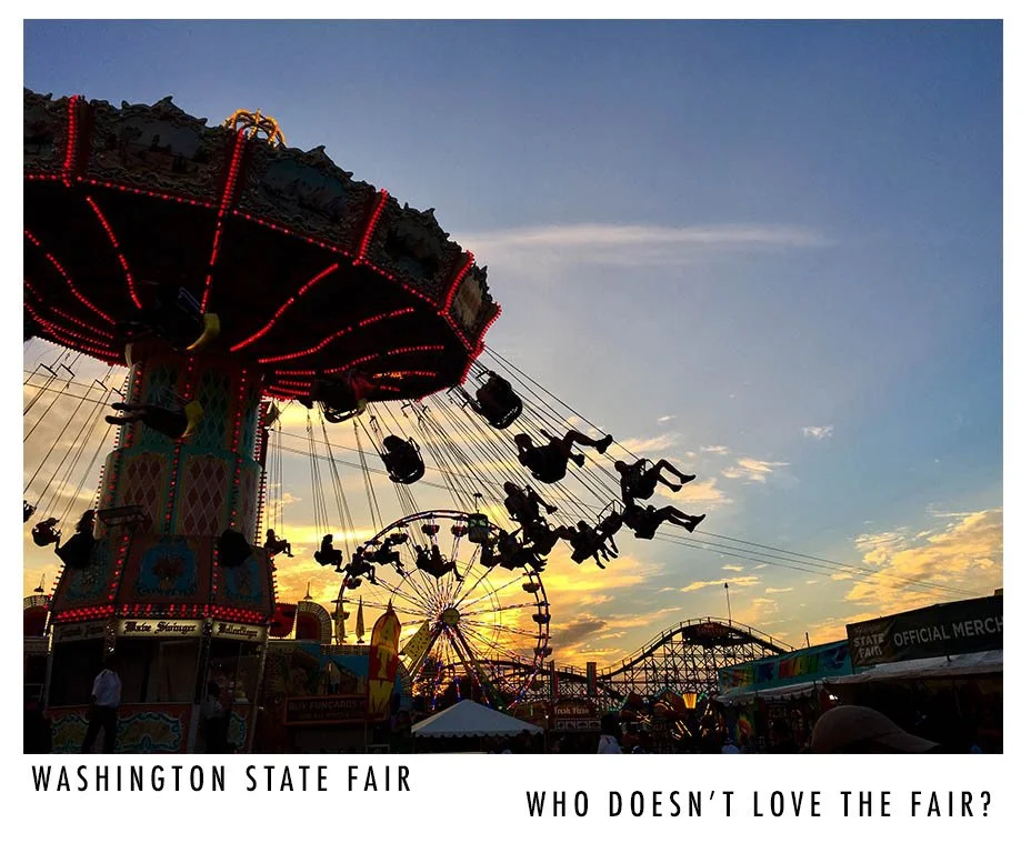 A sunset at the Washington State Fair with a lit-up swing ride and a Ferris wheel in the background.