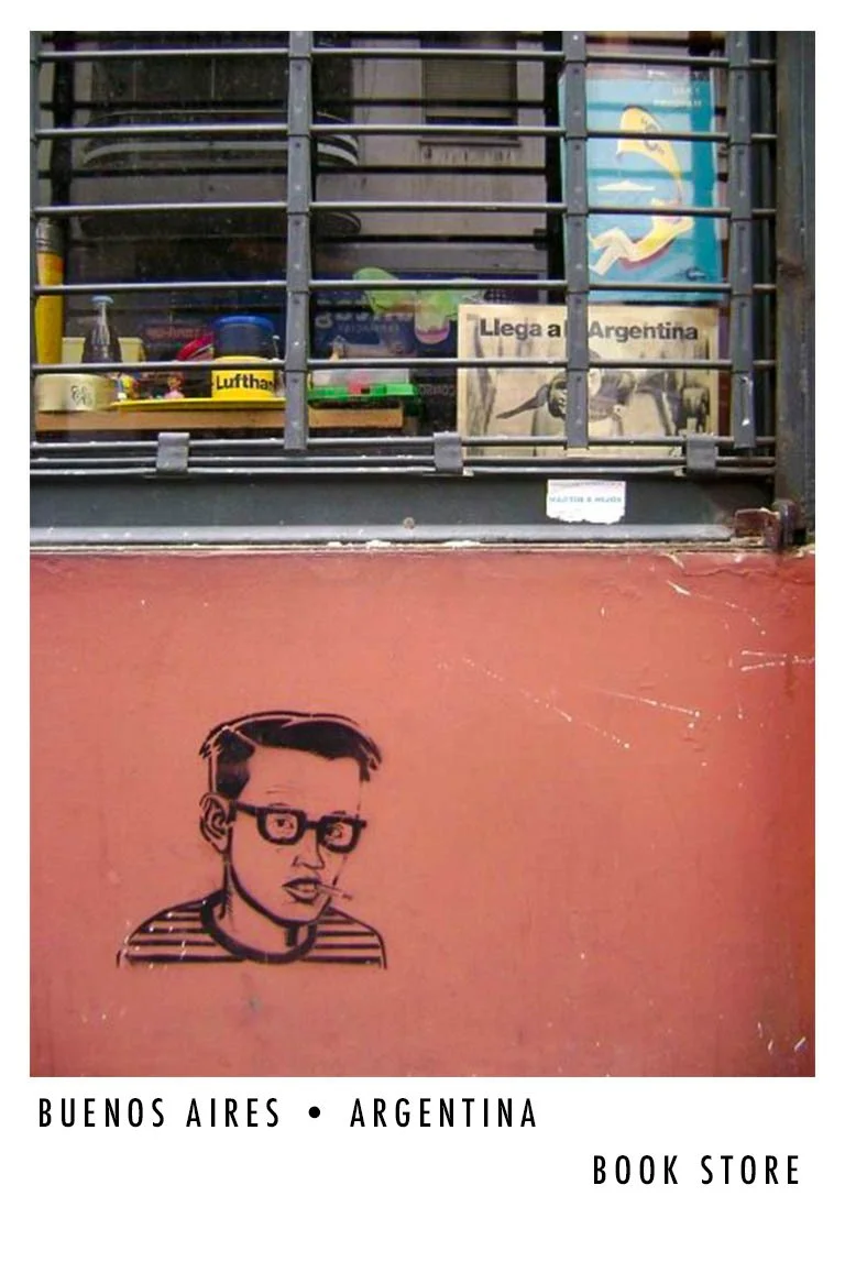 Graffiti of a person with glasses, striped shirt, and a cigarette in mouth, on a red wall below a window with books and objects inside, with a sign reading "Buenos Aires, Argentina, Book Store".