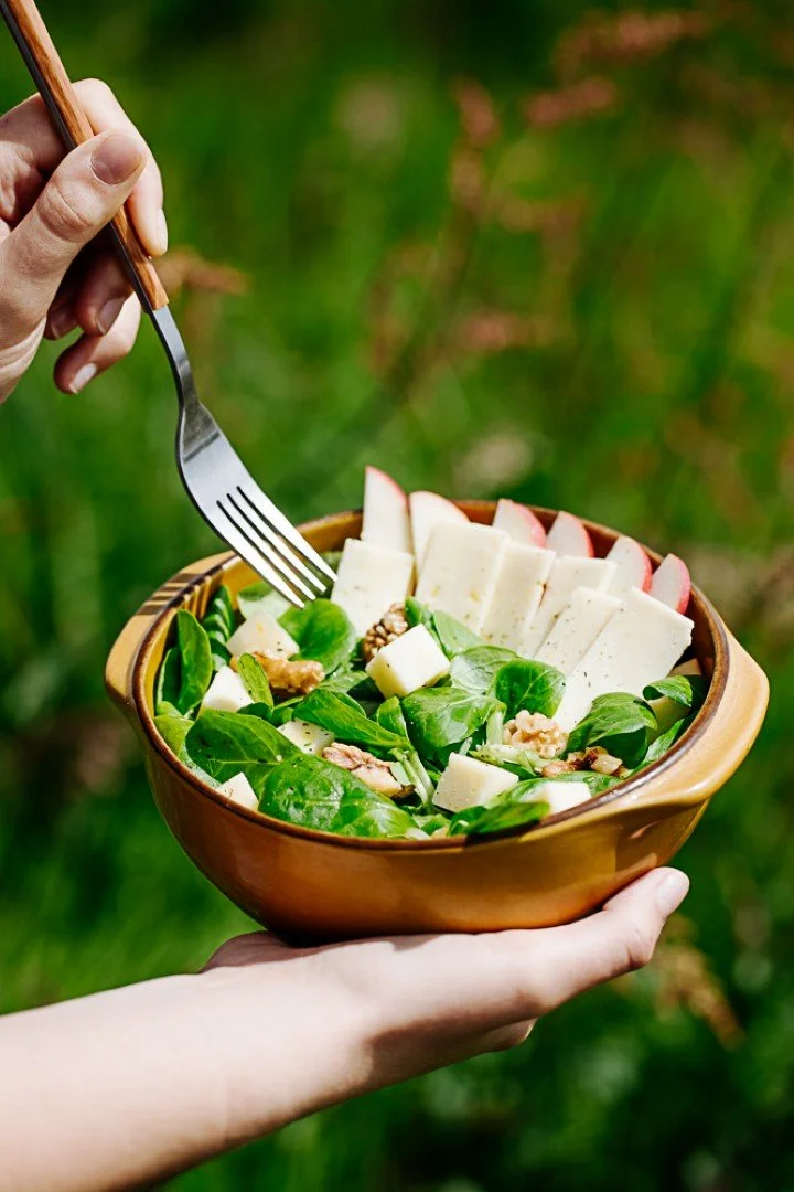 photographie salade estivale en pleine nature, main qui mange