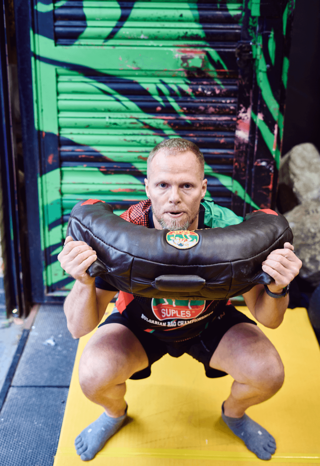 man performs squat and press at Bulgarian bag class in Deptford, London