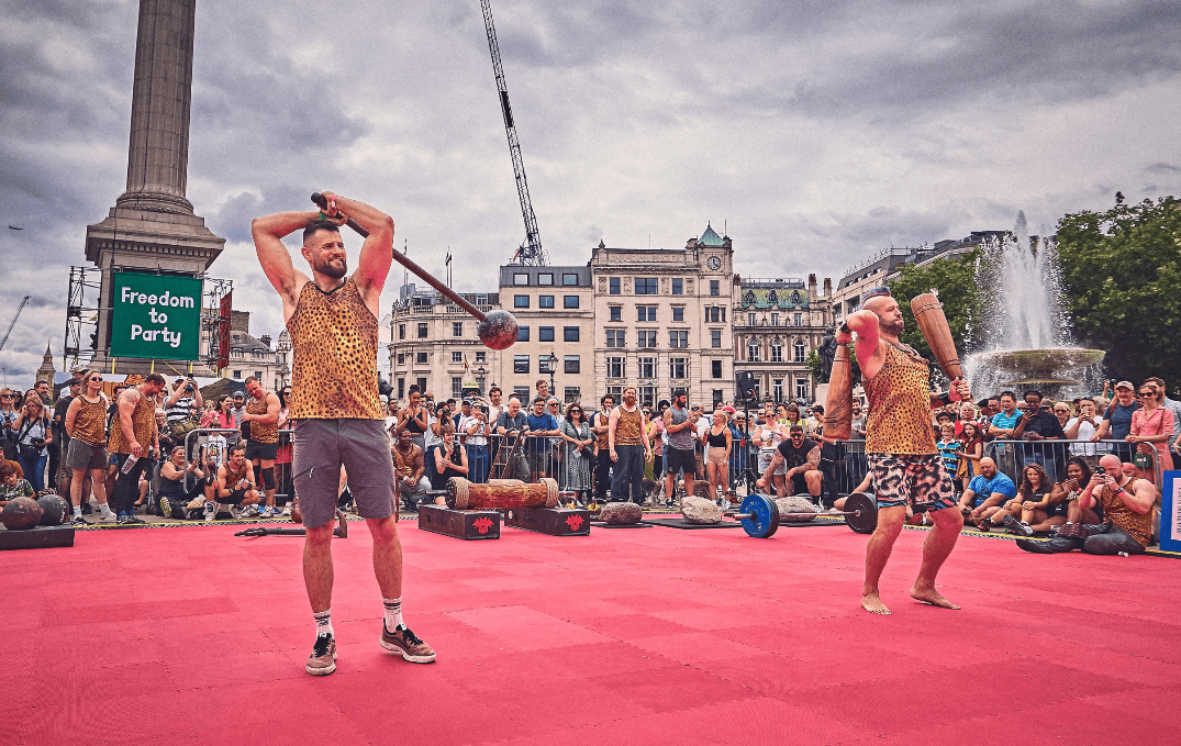 two men dressed in leopard skin swinging mace and Persian meels in Trafalgar Square London