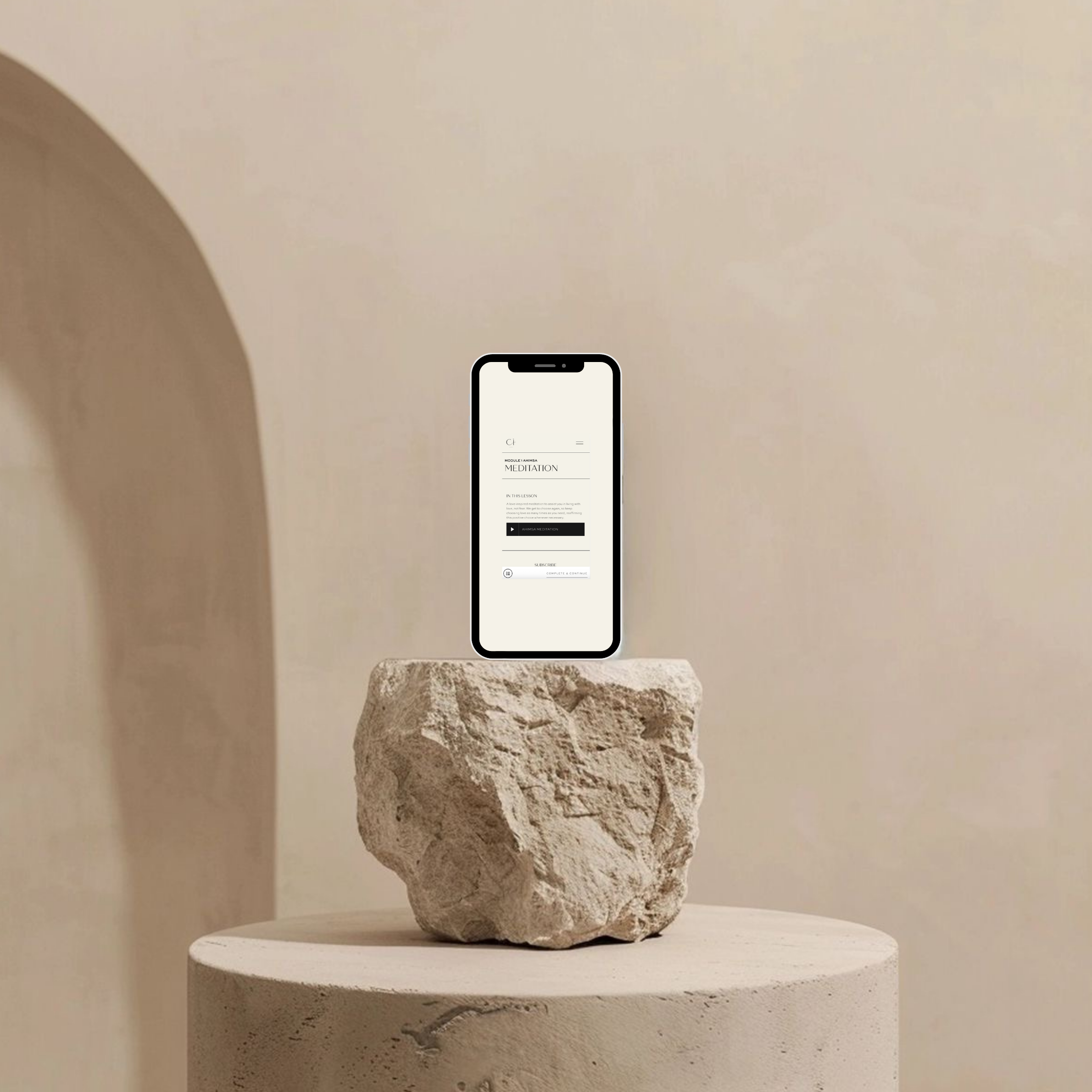 A smartphone placed on a large, textured stone, which is positioned on a round, white pedestal, against a plain beige wall.