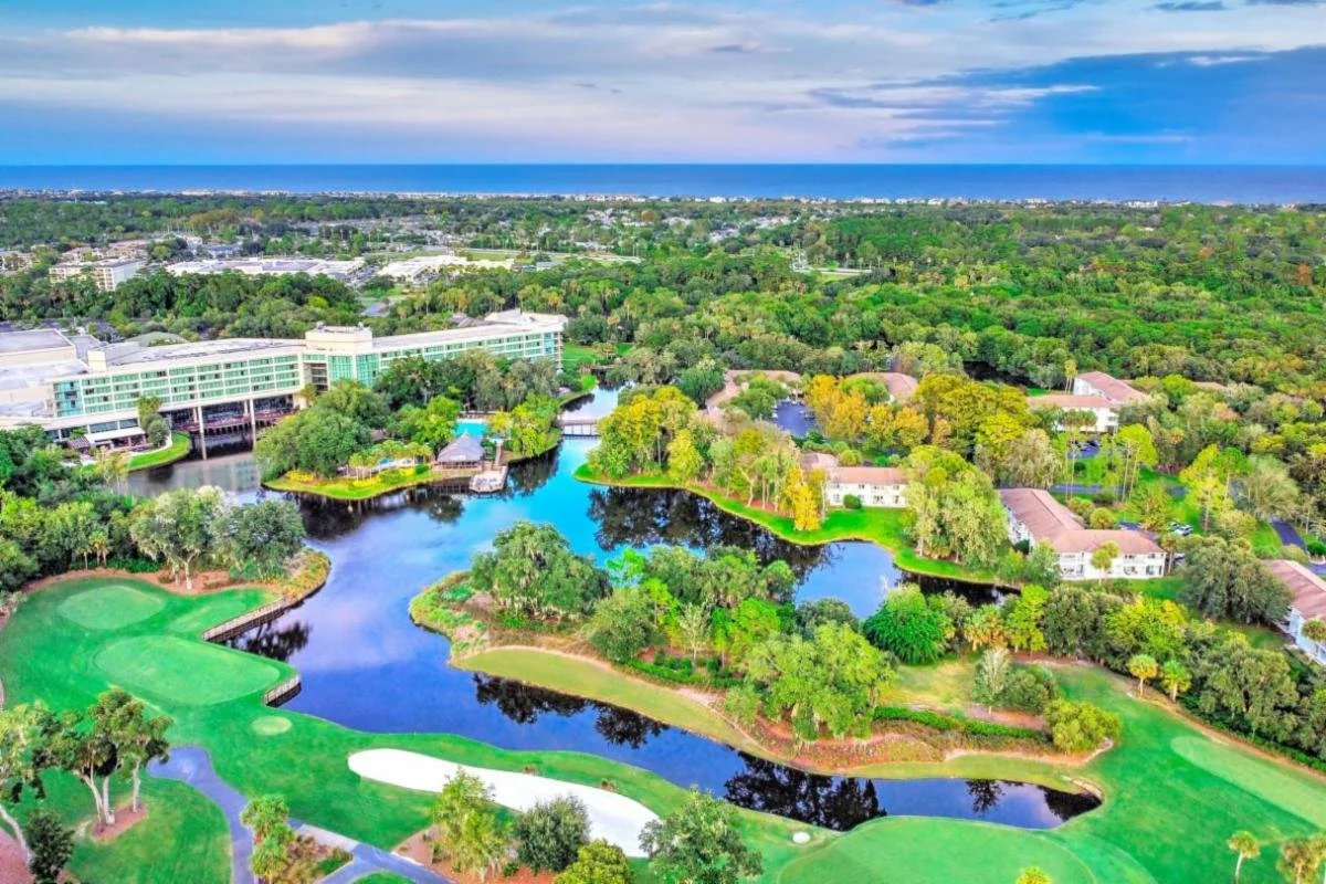 Image of a Florida city scene with a large pond, buildings, and lush greenery surrounding the area