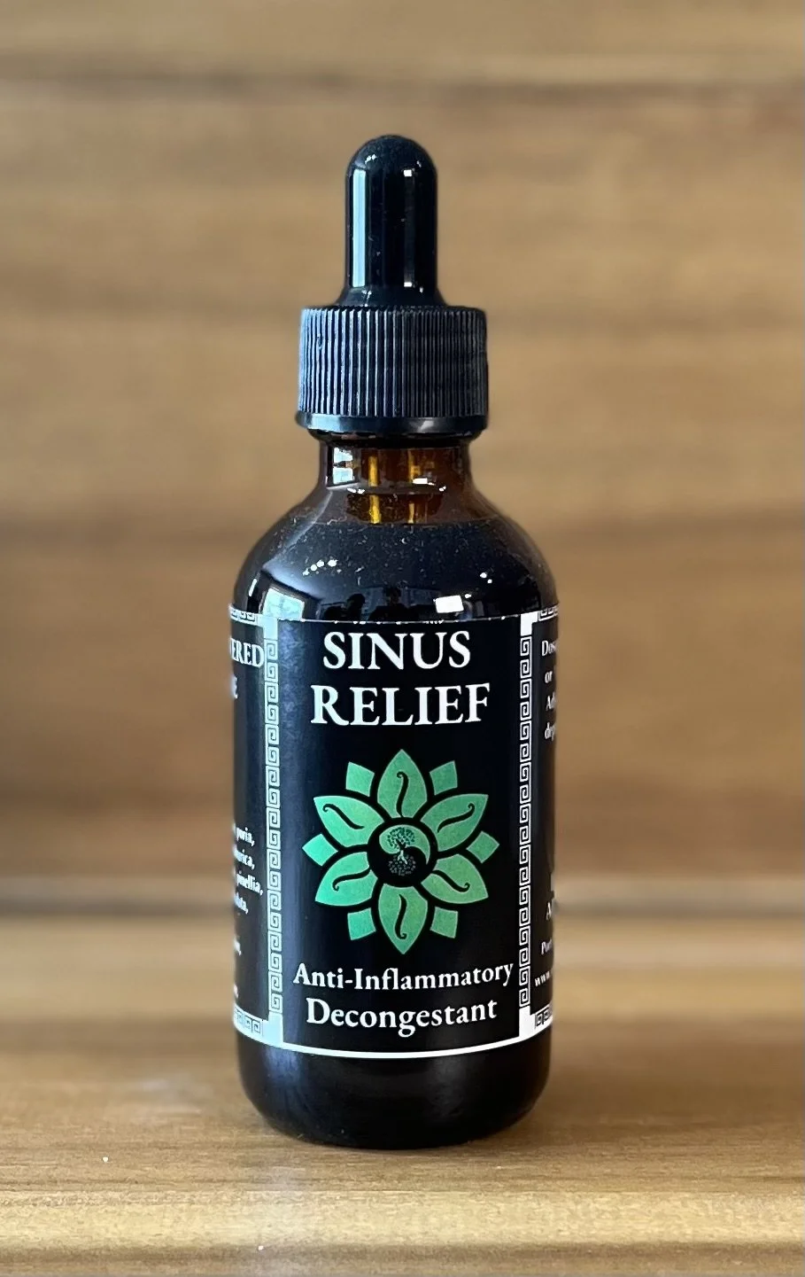 A small dark dropper bottle labeled 'Sinus Relief' with a green floral design, described as an anti-inflammatory decongestant. This is a natural herbal remedy for sinusitis, head colds, allergy symptoms and headaches.
