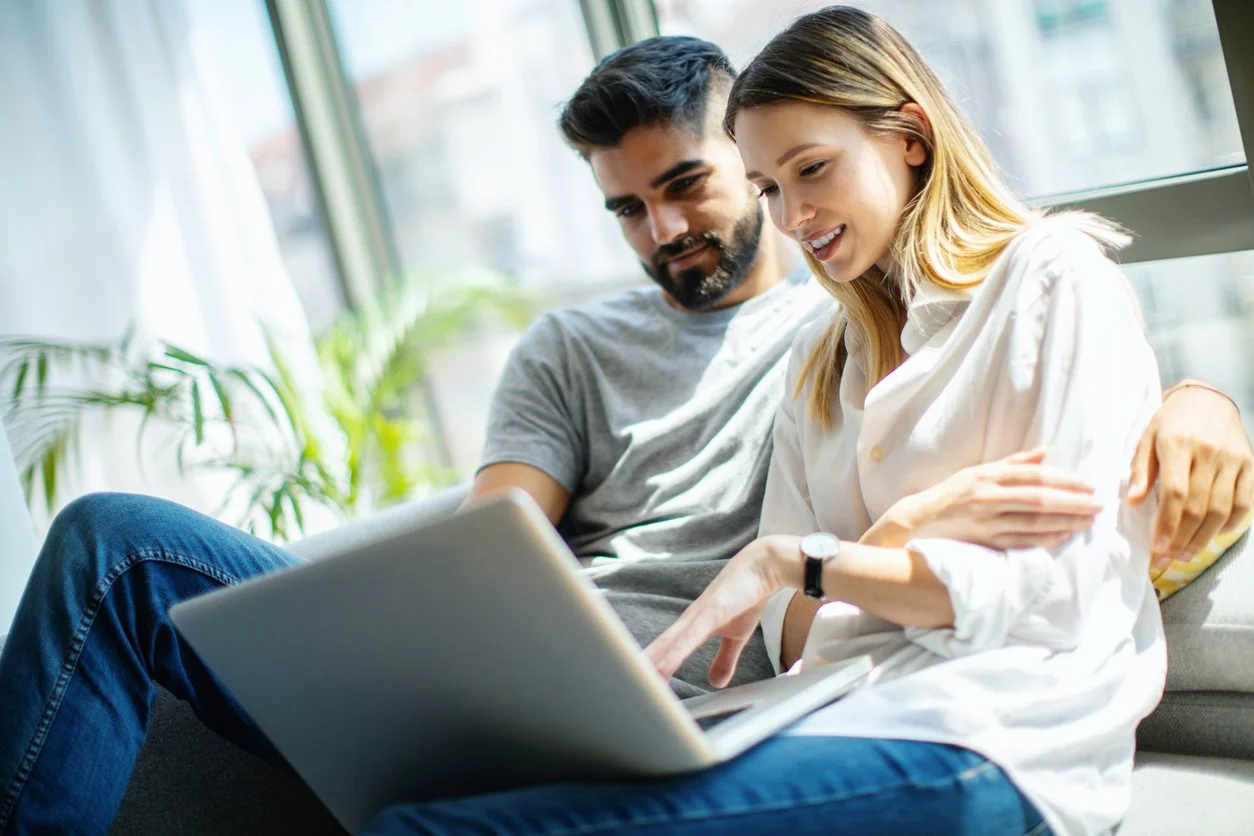 Couple with laptop watching Renovation Marriage online workshop, which helps couples with infidelity recovery with practical tools for forgiveness and rebuilding trust.