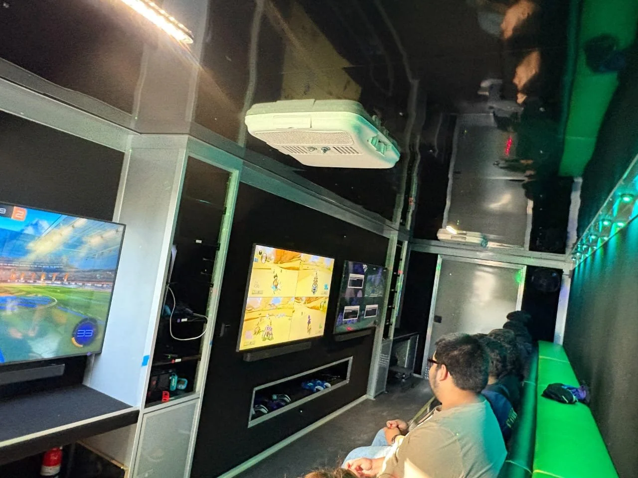 People playing video games on multiple screens in an arcade or gaming lounge