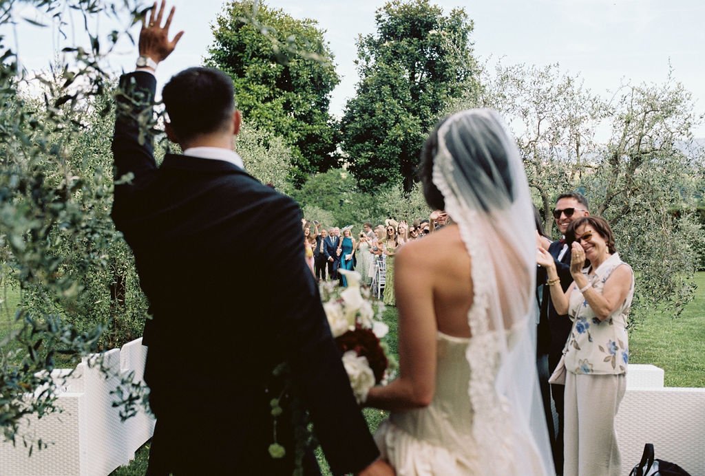 Wedding ceremony outdoors with bride, groom, and guests.