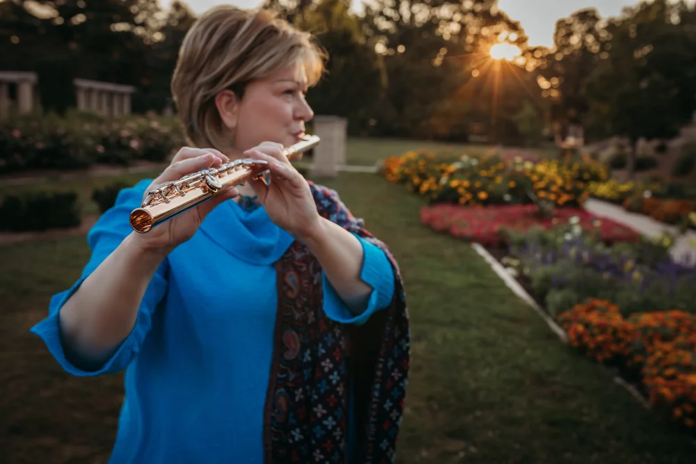 Lynne Stukart holding a wooden Native American style flute