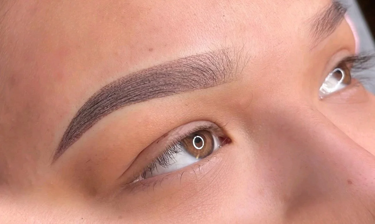 Close-up of a person's eye with well-groomed eyebrows.
