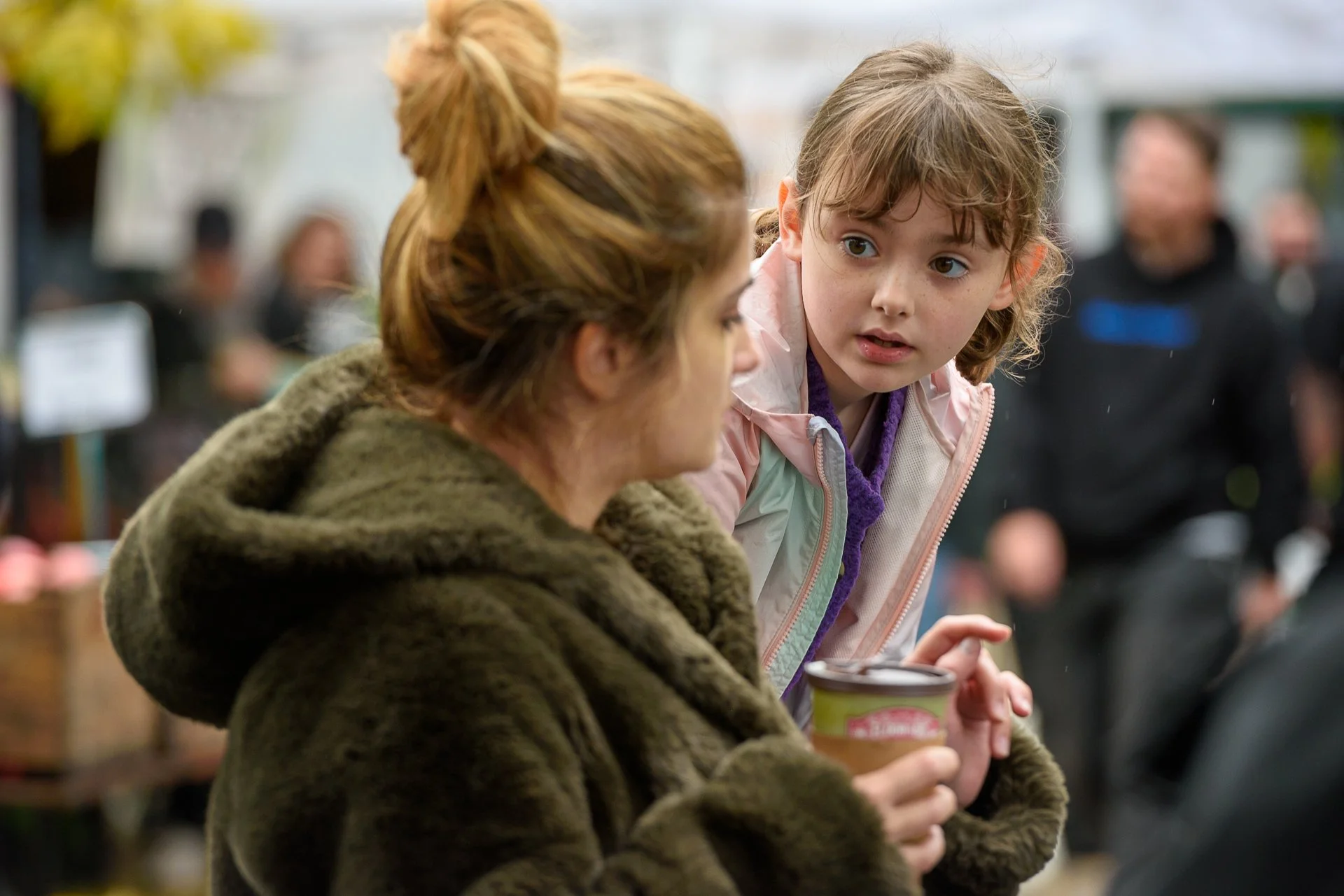 Woman and girl talking at an outdoor market