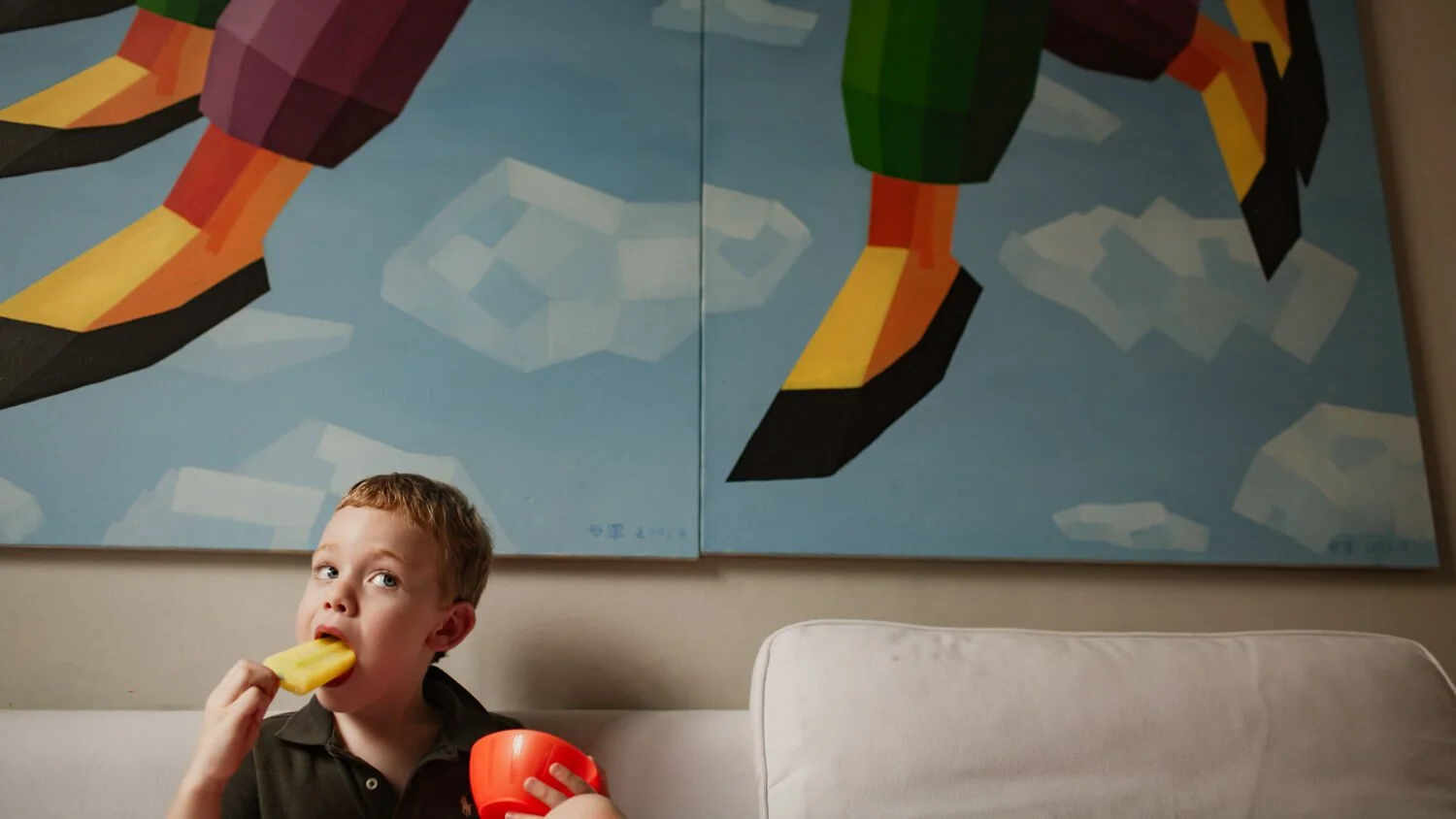 Boy eats yellow popsicle at The Peak, HK