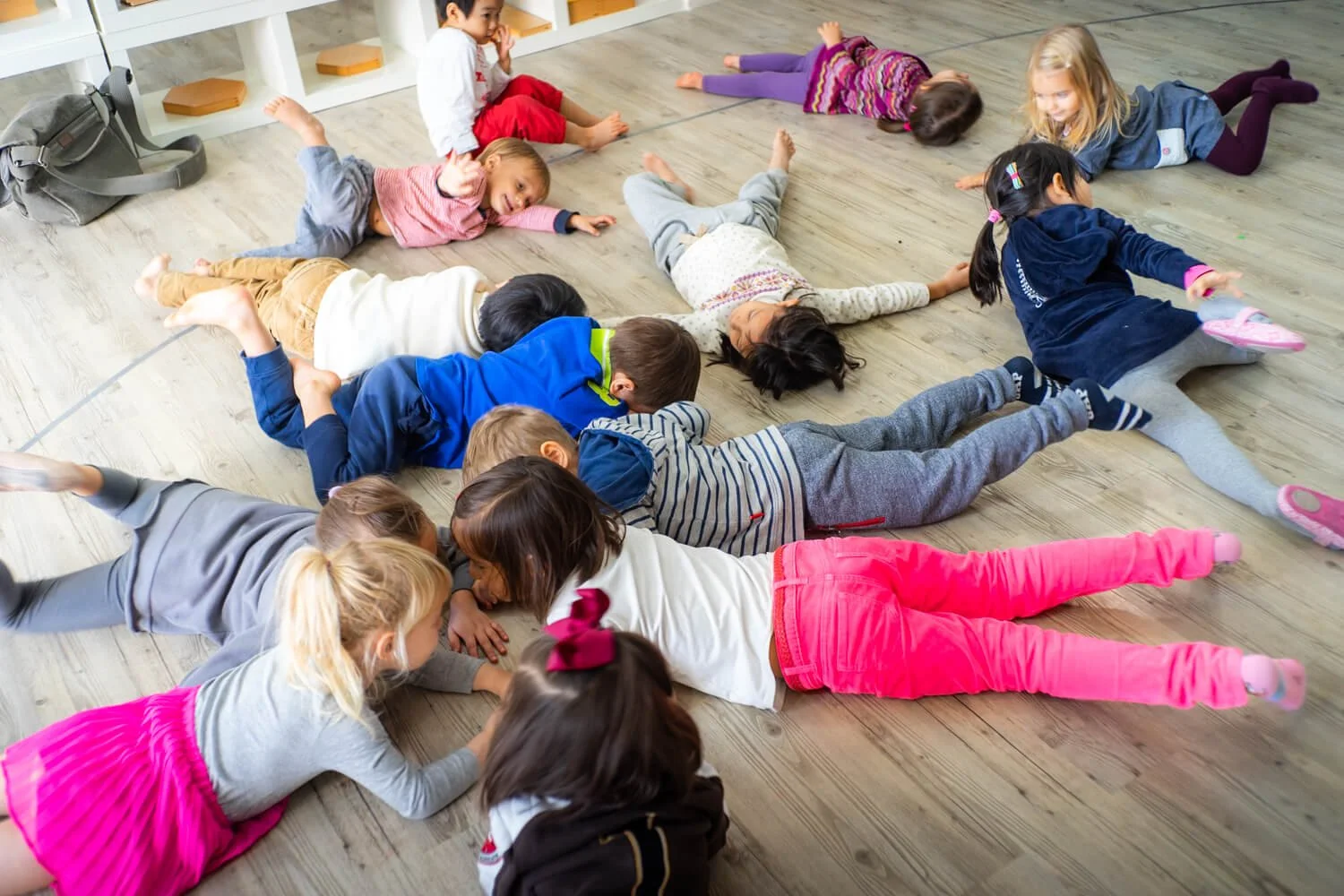 A large group of kids interact on the floor of the school by Ian Taylor