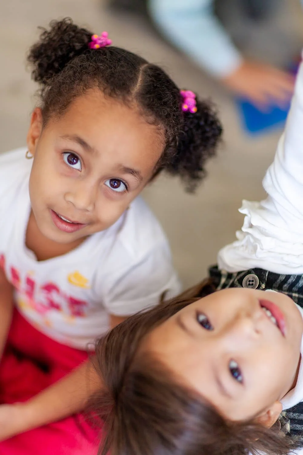 Candid moment of two girls in a classroom; captured by Hong Kong family and school photographer Ian Taylor.