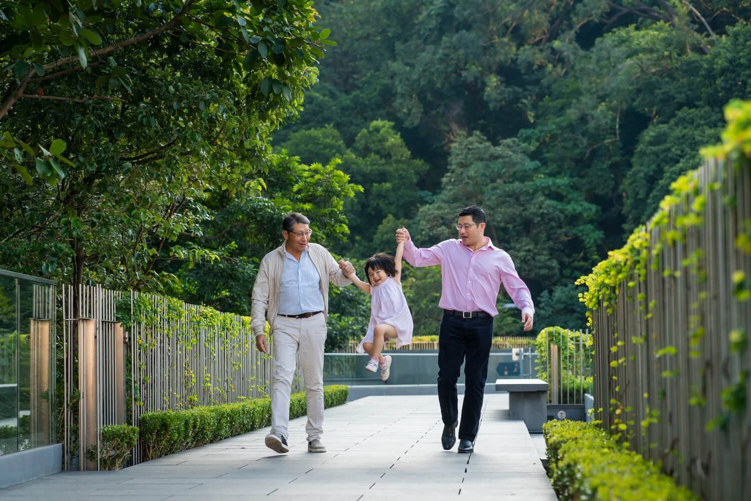 Dad and granddad swing a kid at The Asia Society, Admiralty