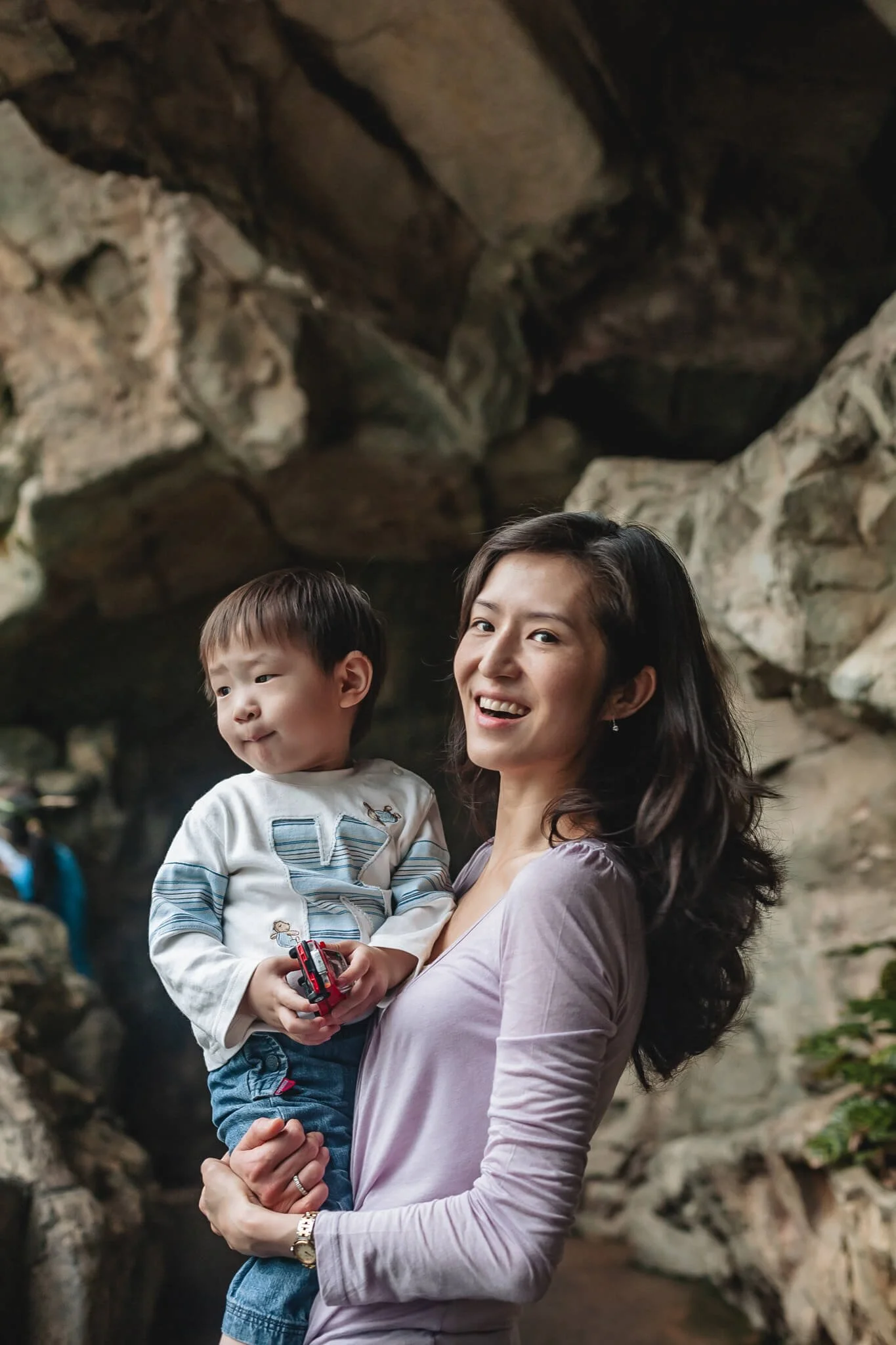 Mom holds her son at the waterfall in Hong Kong Park