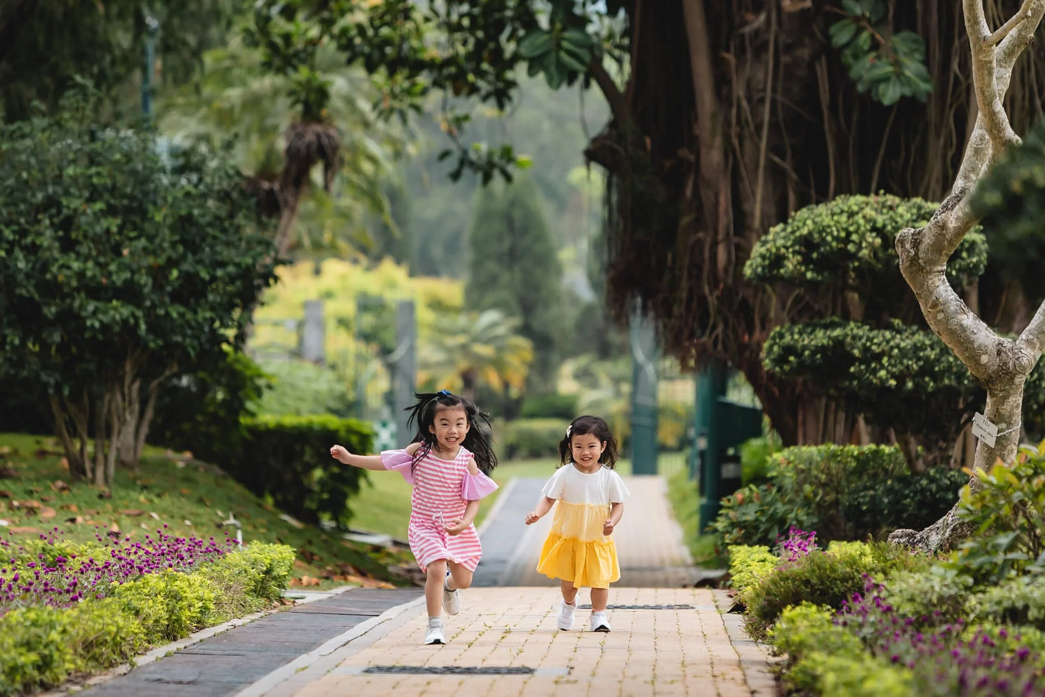 Sisters running in the green backdrop of the Beas River Club, NT, Hong Kong