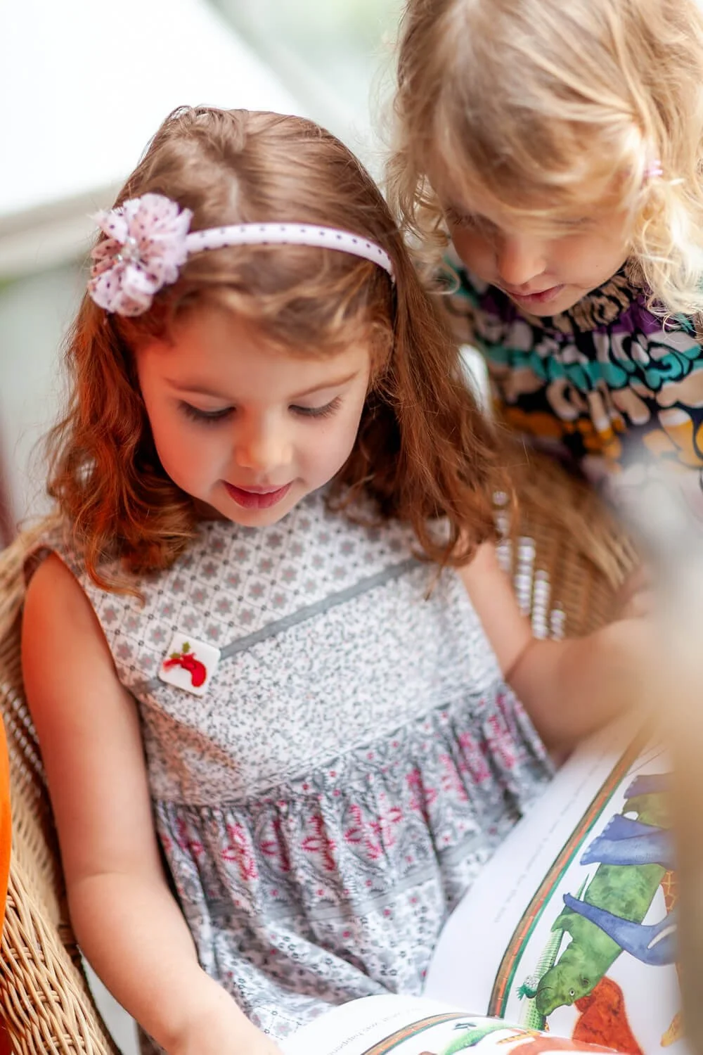 Girls quietly read a book together photo by Ian Taylor