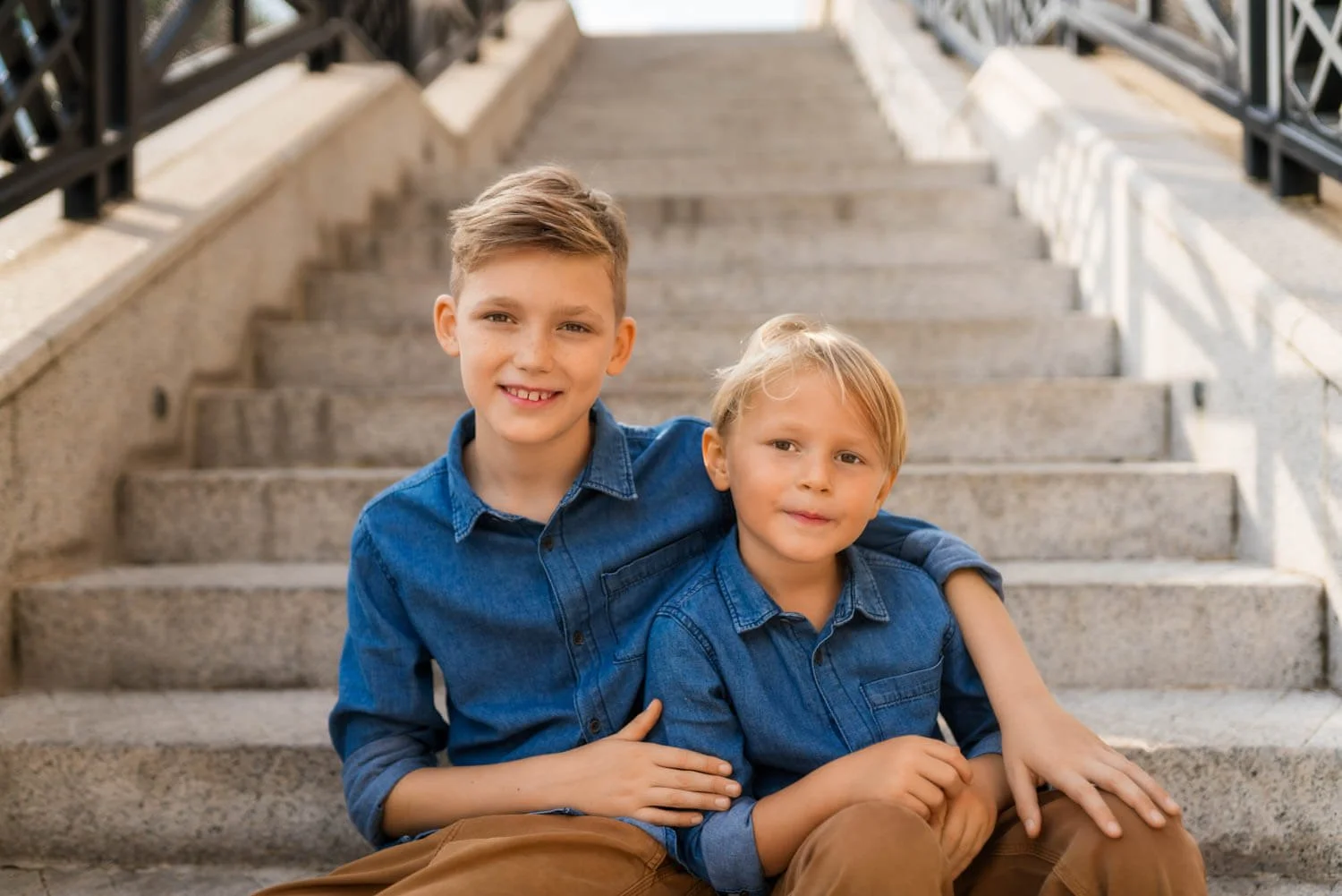Brothers sit on the steps of Murray House during a family photo session with Ian Taylor