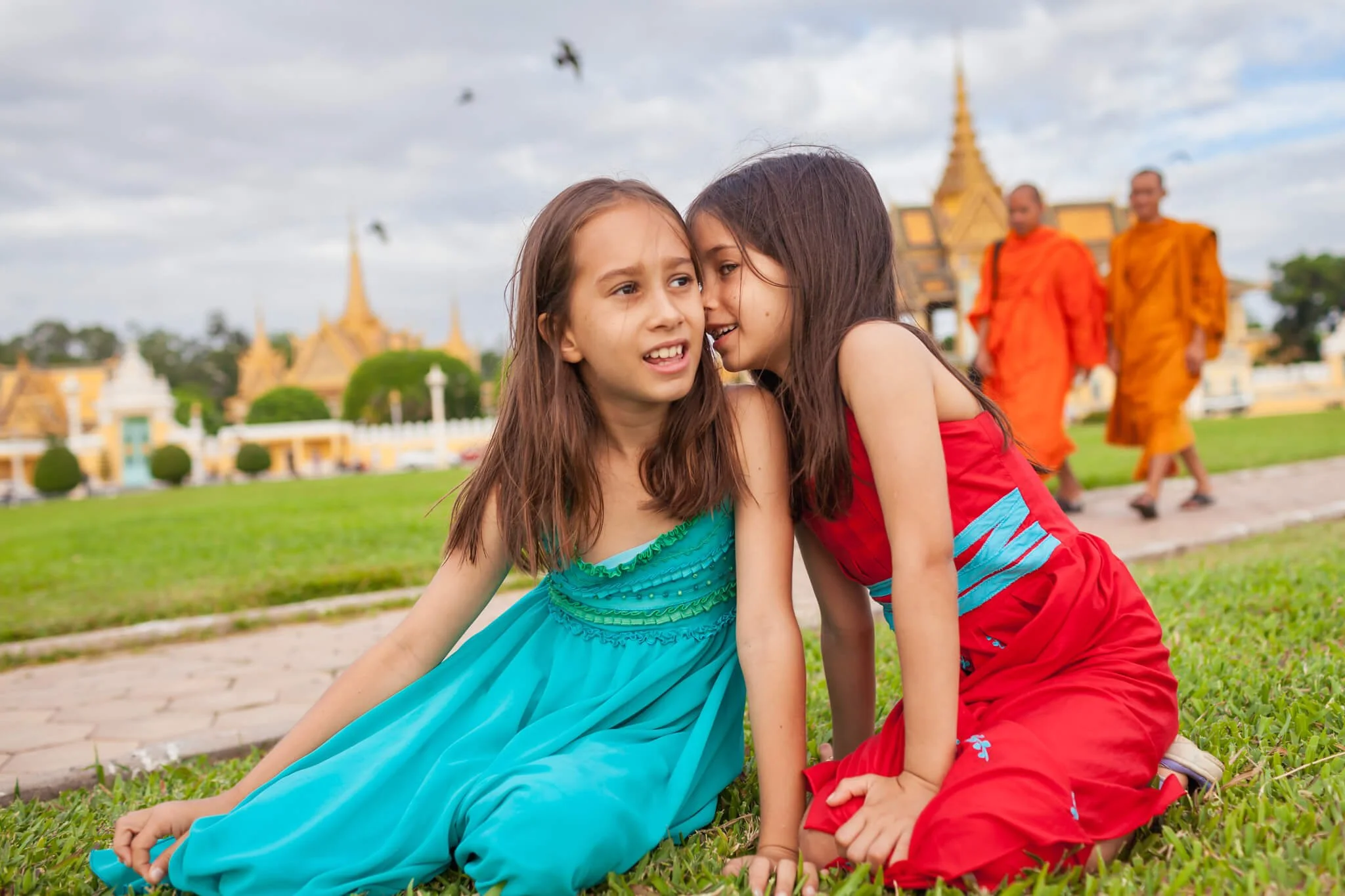 In Phnom Penh girls sit in front of the Royal Palace