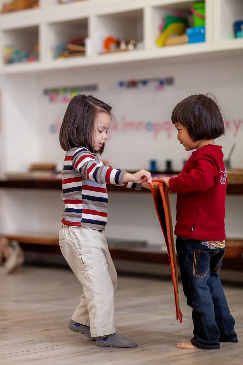Girls work together to put out a matt at a Montessori school in Hong Kong