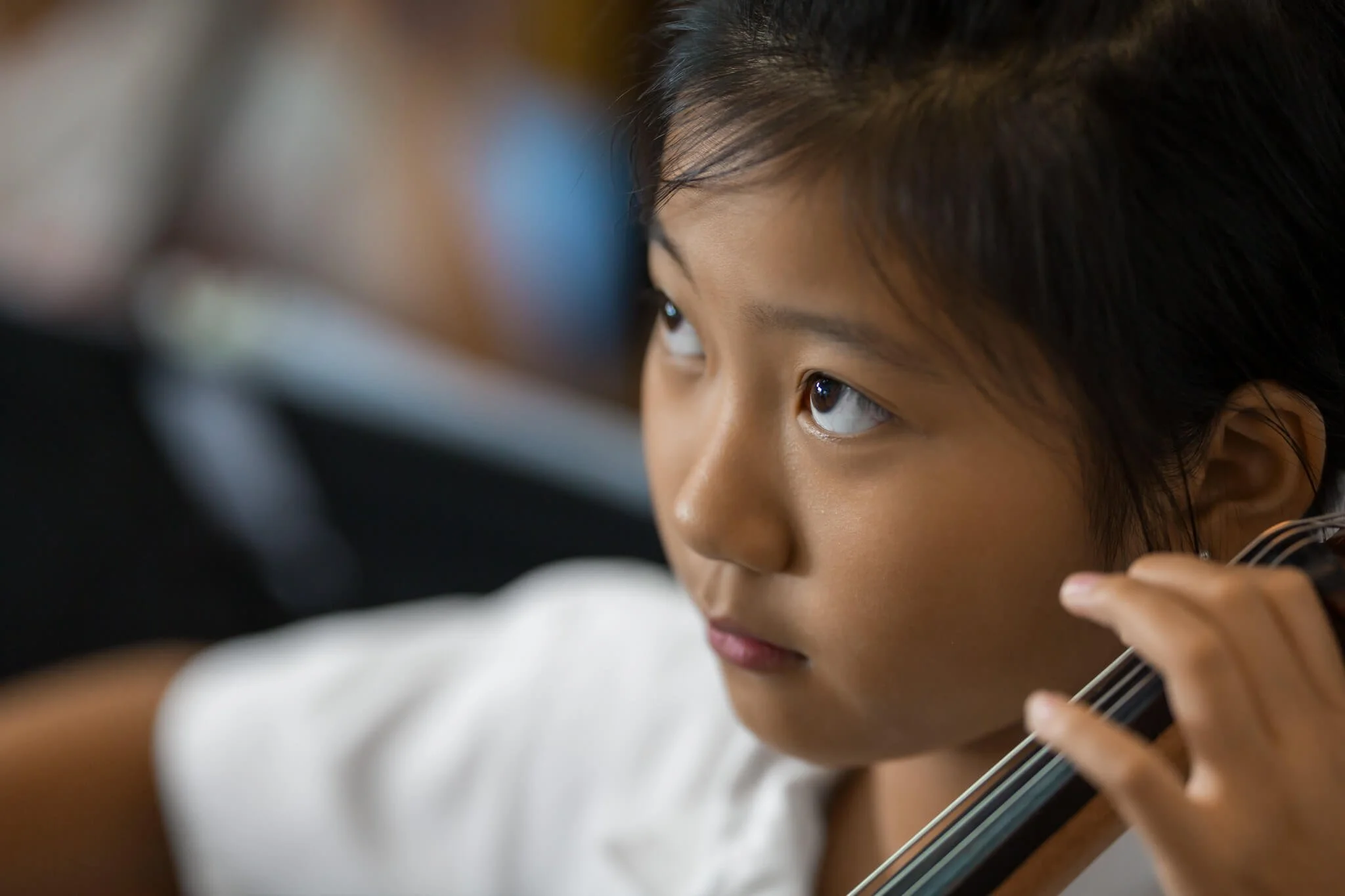 Girl concentrates while learning cello at Kingston International School HK