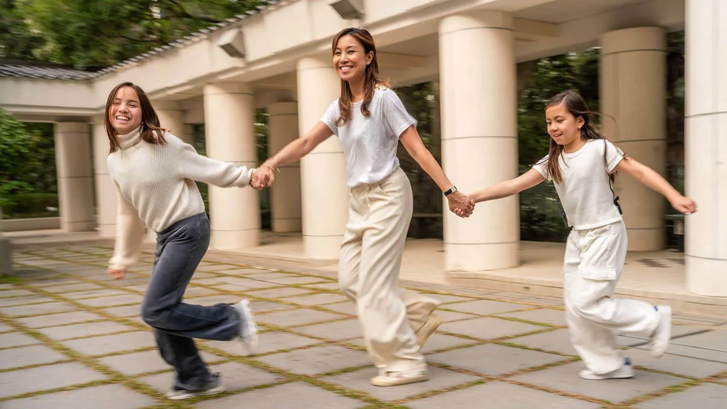 Mom and daughters run for family photos at Hong Kong Park.