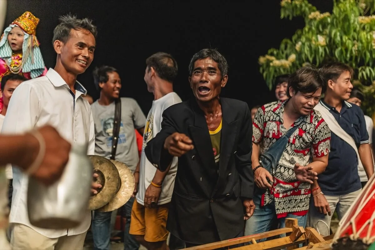 Lua man telling stories while musicians play around him