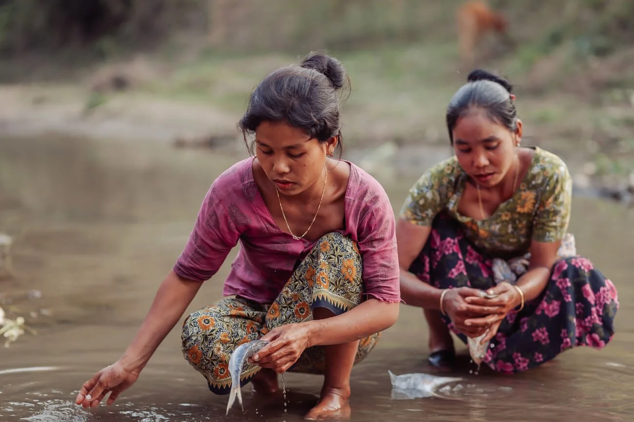 Chakma woman clean fish in a stream in Khagrachhari District