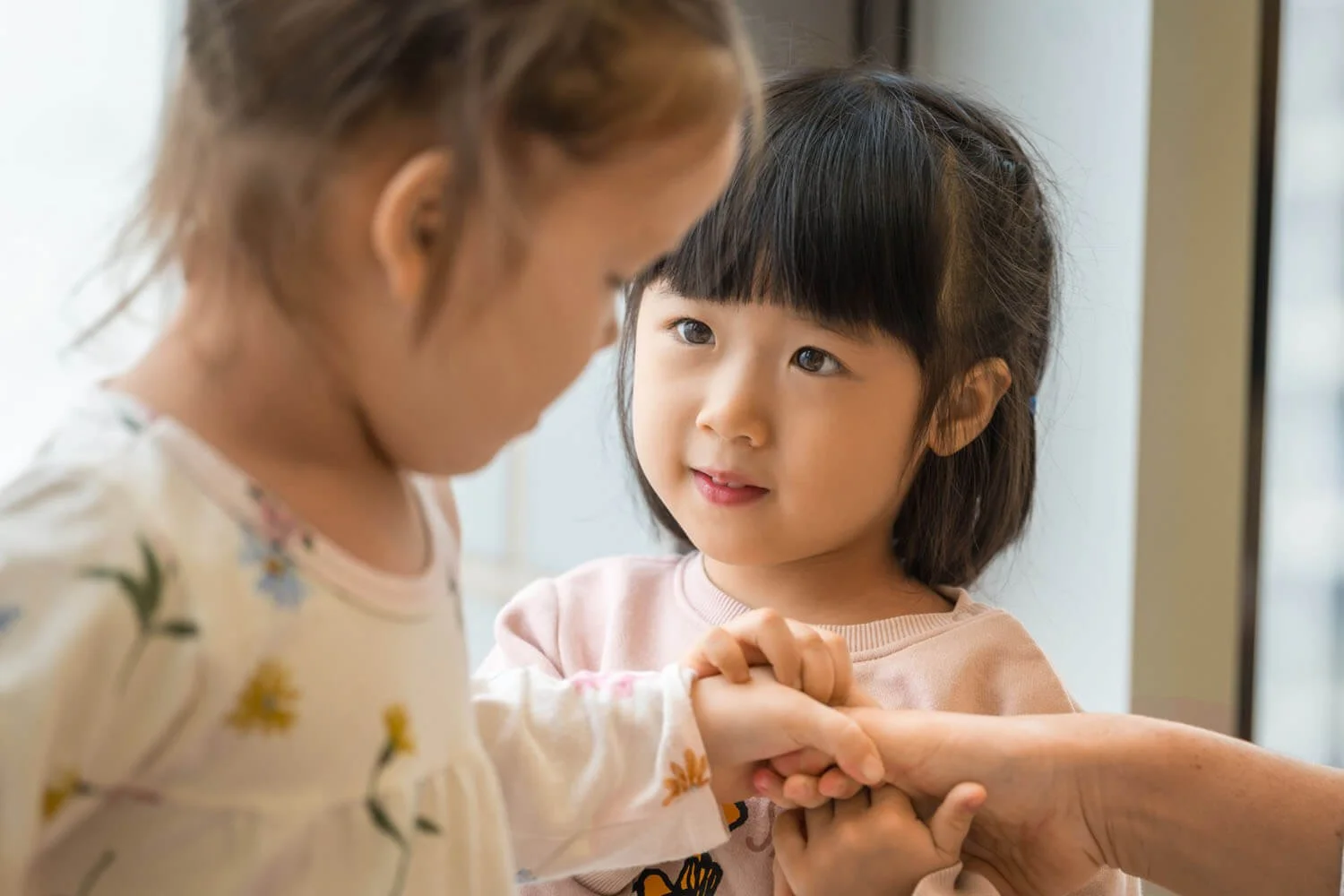 Girl hold the hand of another kid at Fairchild Academy Hong Kong