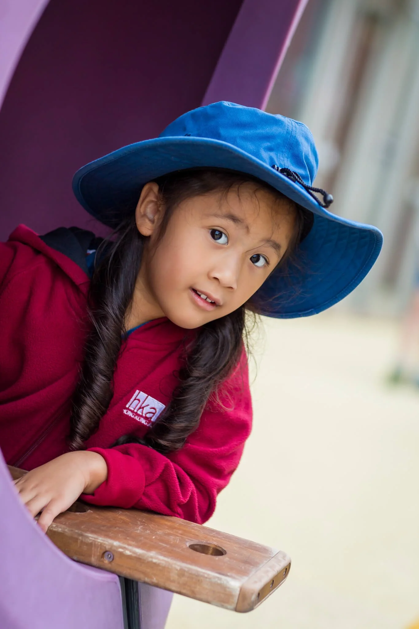 At Hong Kong Academy, a girl plays in the playground with her school uniform on.