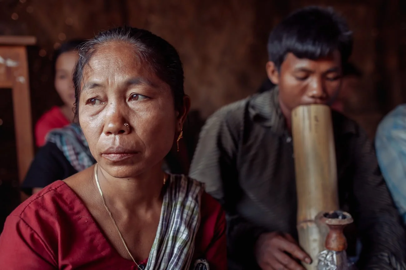 Chakma woman with man smoking large bong of tobacco. 