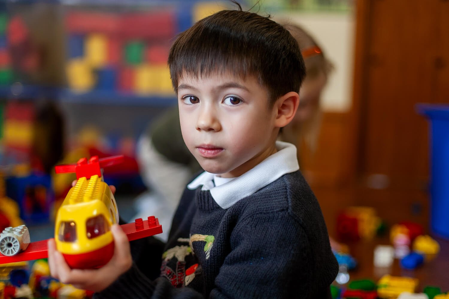 Boy holding a toy helicopter at school in HK