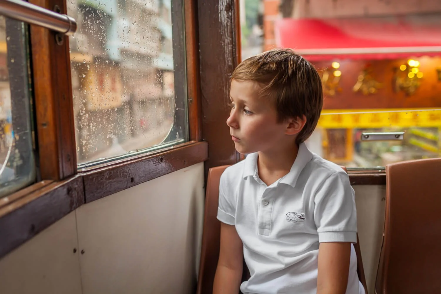 Boy on a tram in the rain, Hong Kong documentary family photography