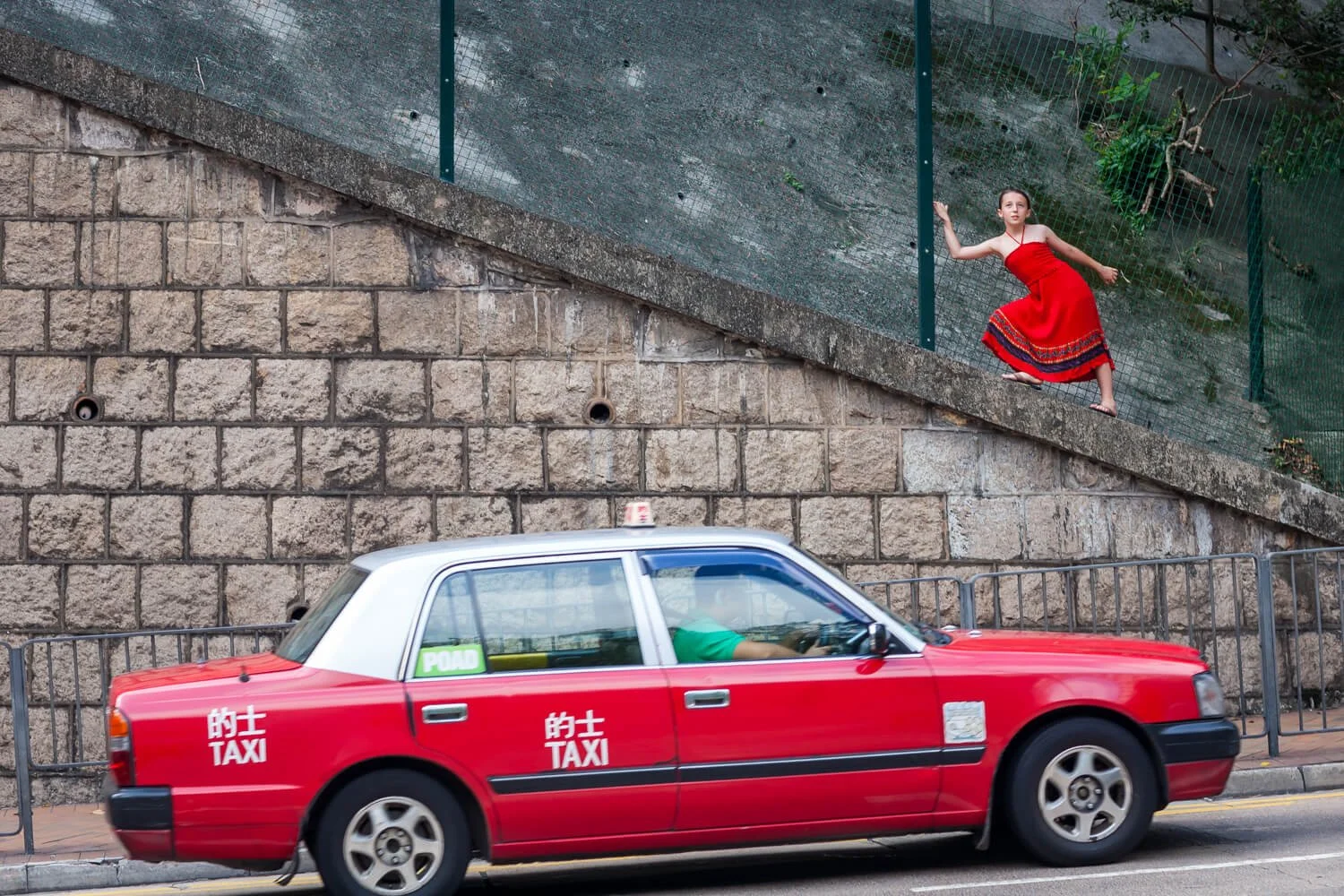 Dancer in red poses on a wall in Wan Chai HK on a documentary-style photo session

