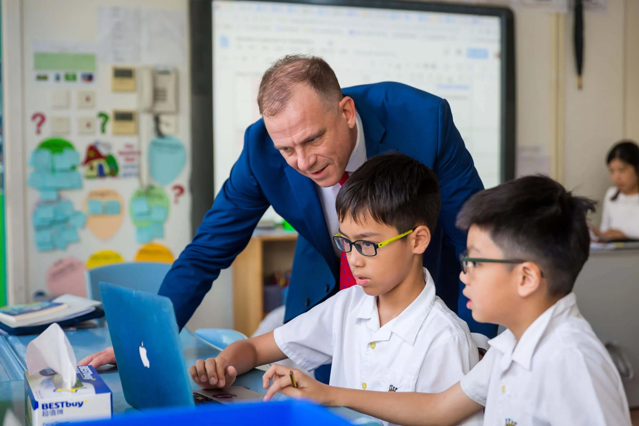At Kingston International School, Hong Kong, the headmaster checks on the work of two students.