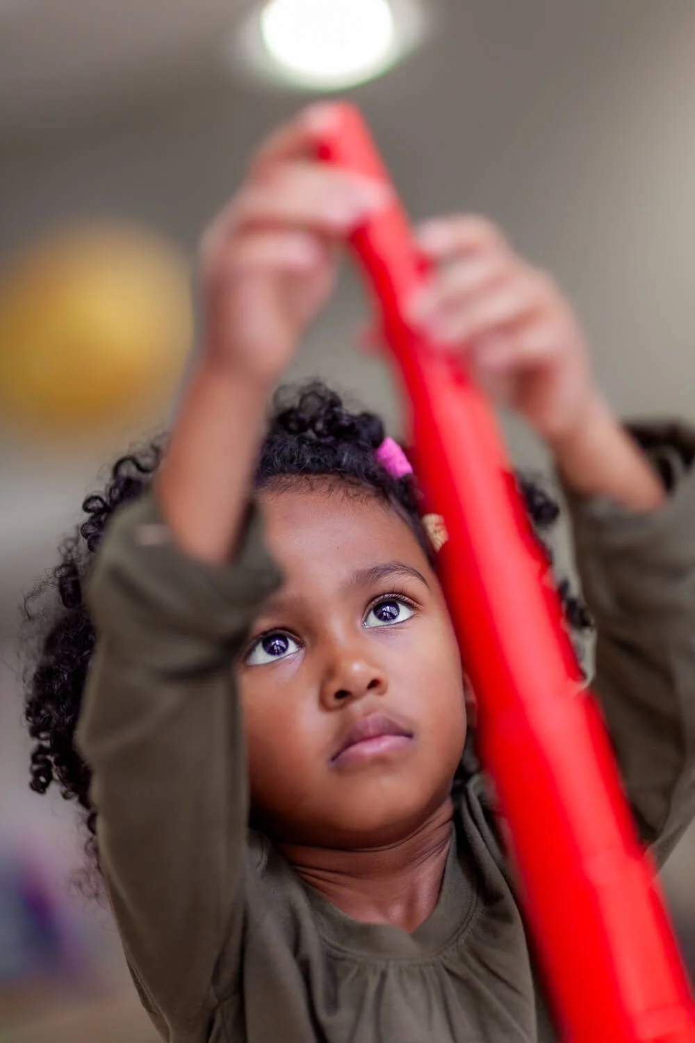 Child concentrating on Montessori sensorial materials in a Hong Kong classroom; documentary school photography by Ian Taylor