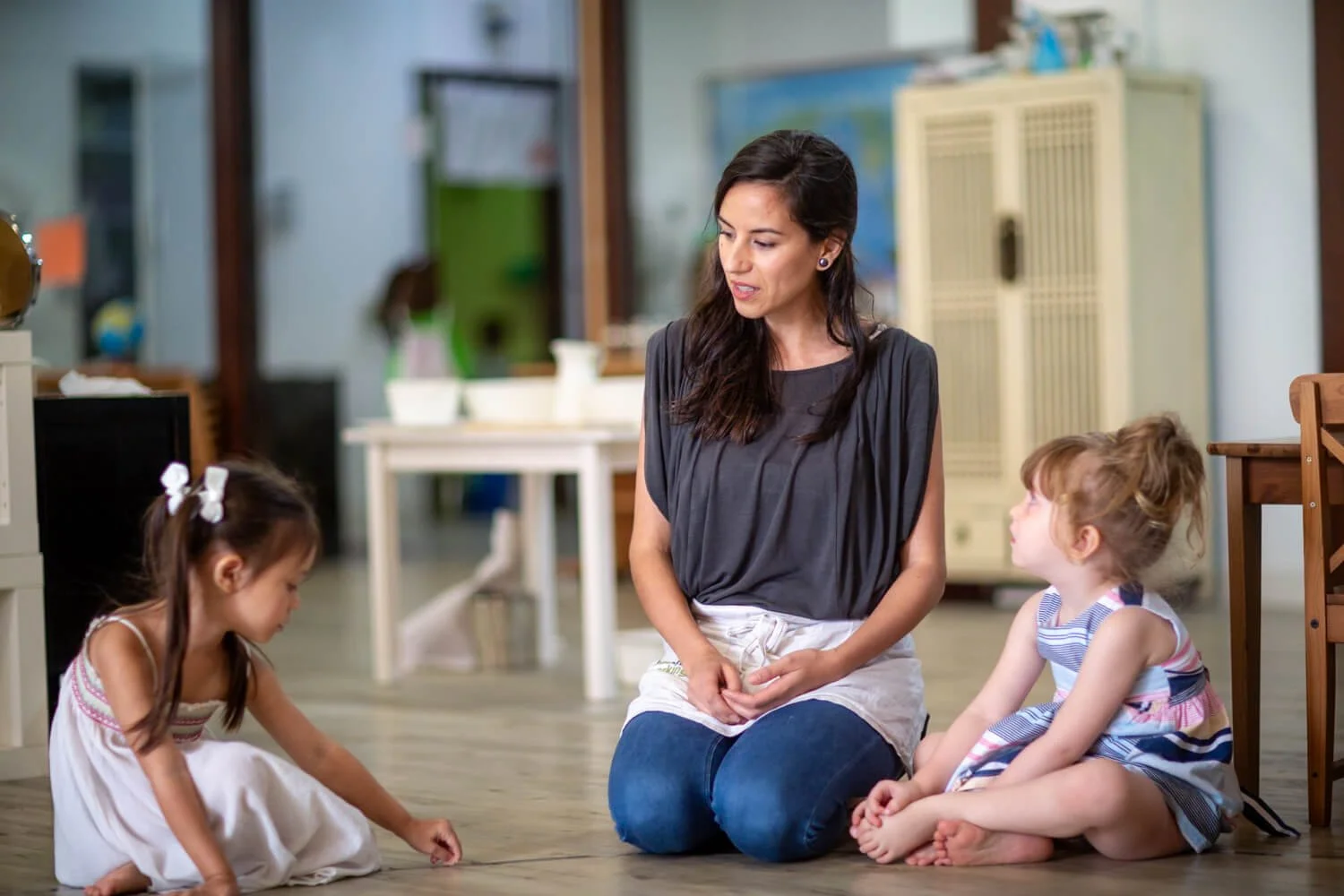 Teacher works with two girls in a natural light environment