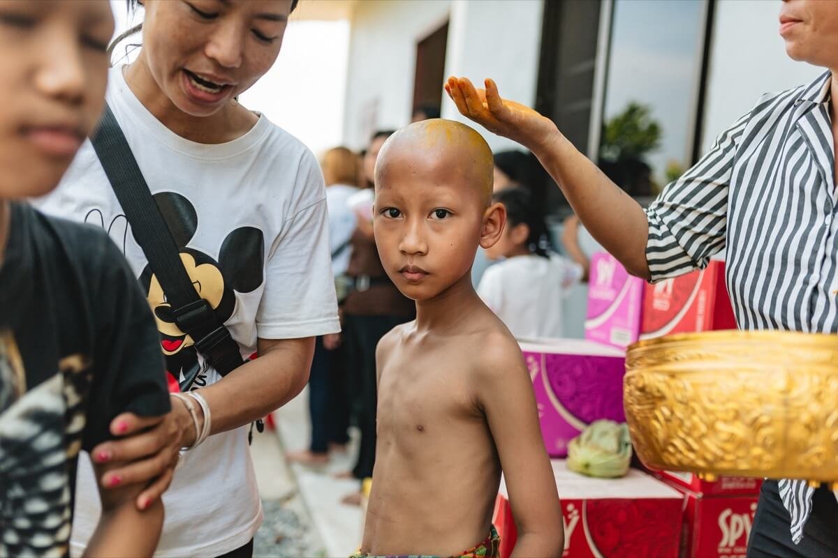 Lua boy's head is rubbed with tumeric after being shaved.