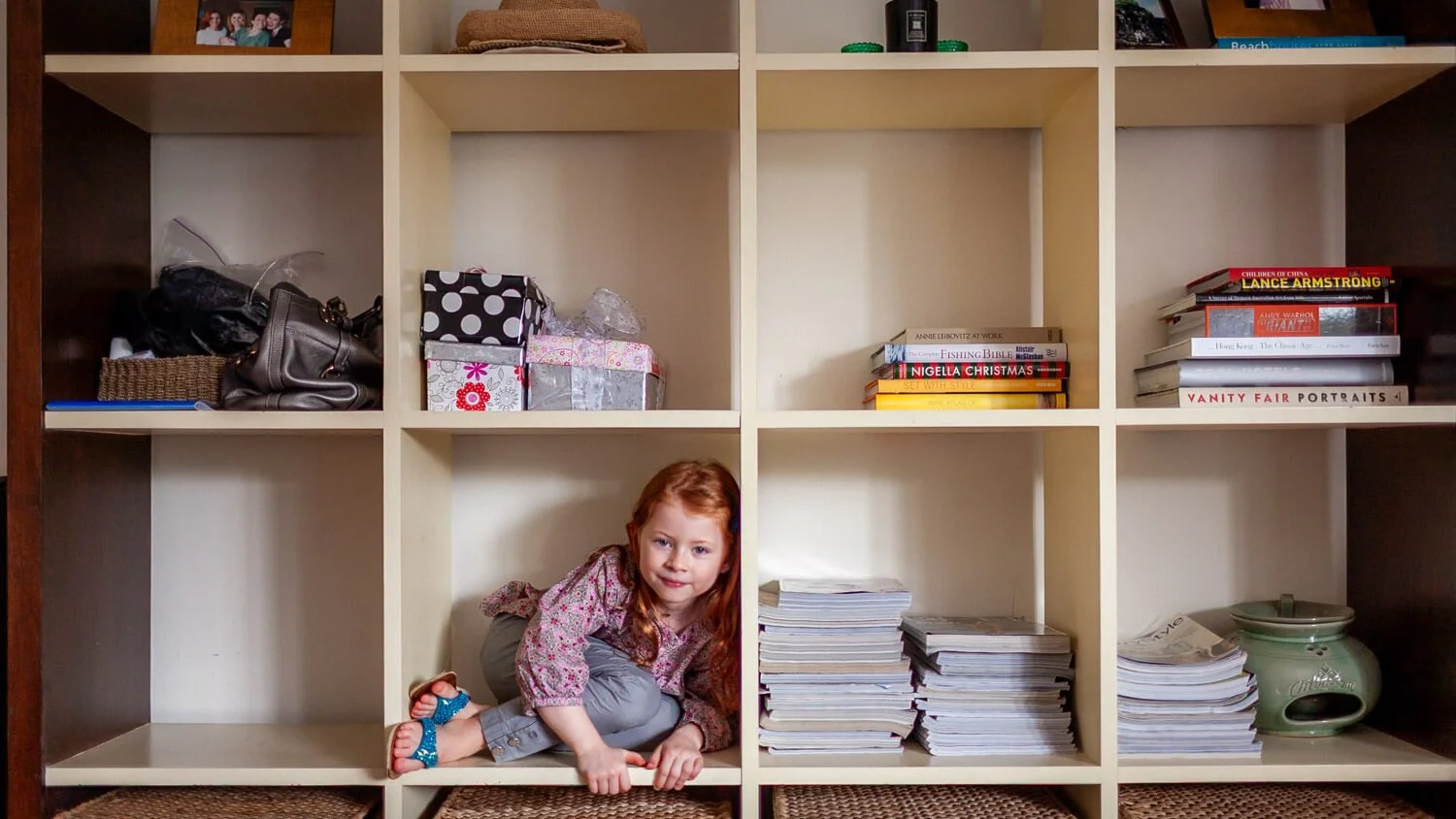Girl hides in a bookshelf at The Peak HK