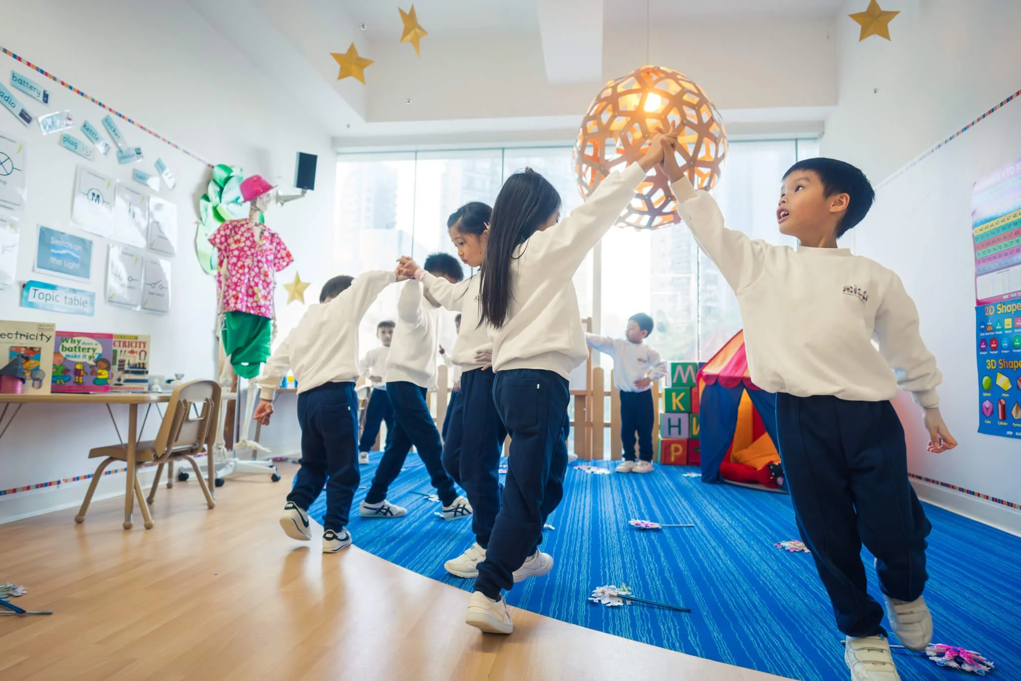 At Mills School, HK kids play a game by walking together in circle.
