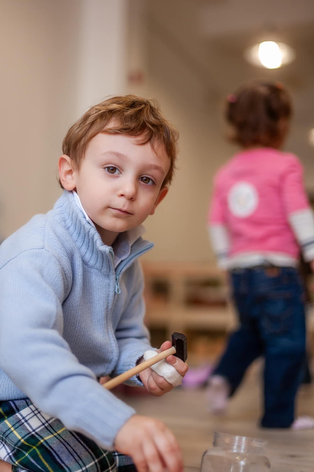 Toddler practicing Montessori practical life skills; unposed photography for international school marketing and differentiation.