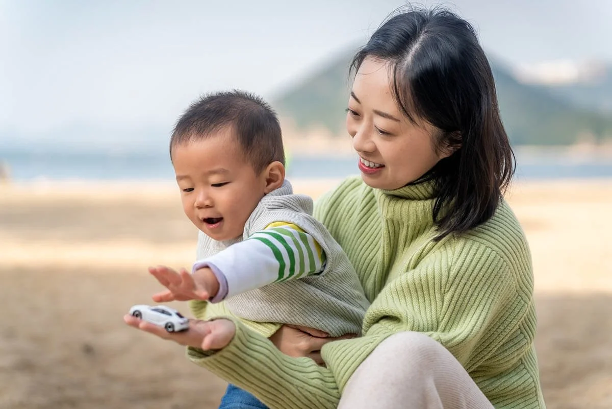 Mom and son play on the beach natural photoshoot