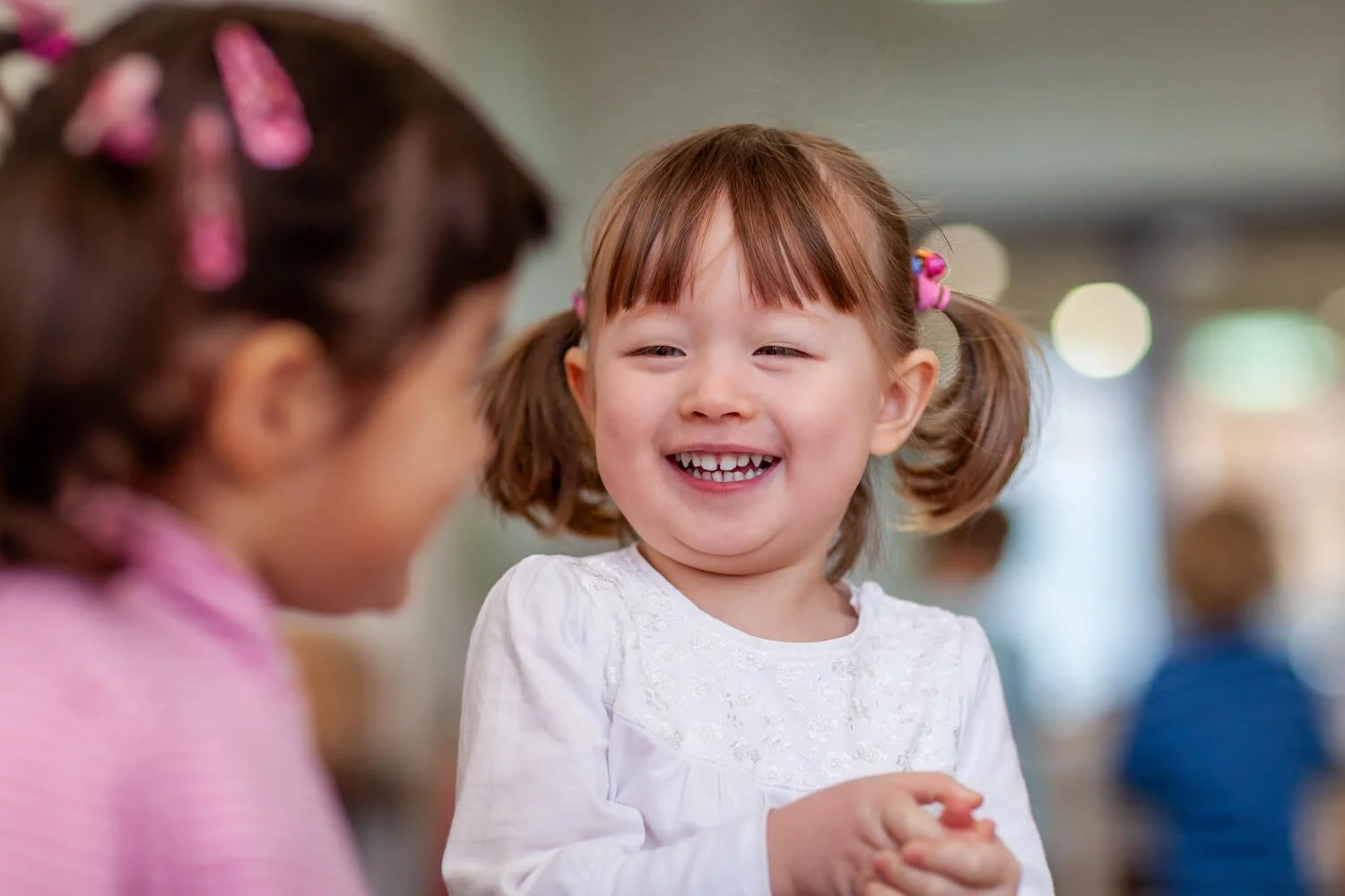 Spontaneous laughter during a Montessori work cycle; natural light school photography in Hong Kong.