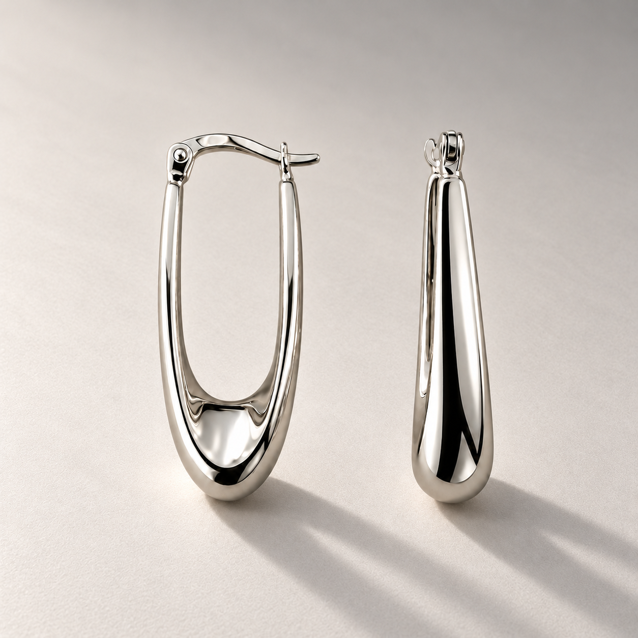 Silver earrings with long studio shadows.png