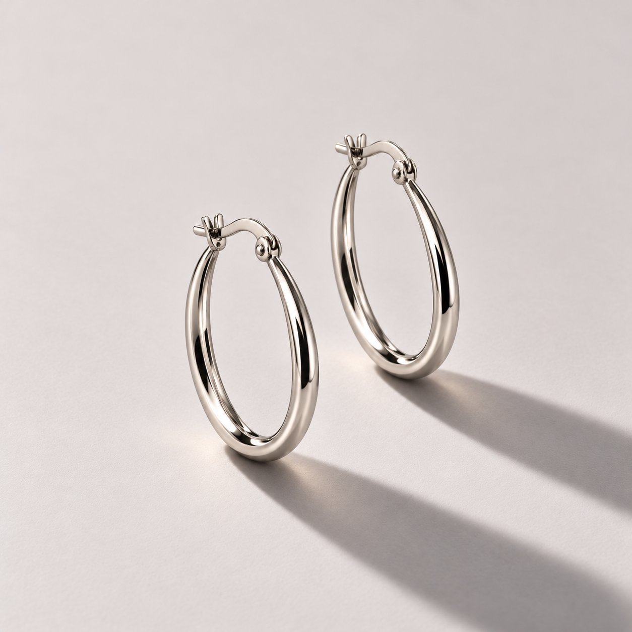 Polished silver hoops in warm studio light.png