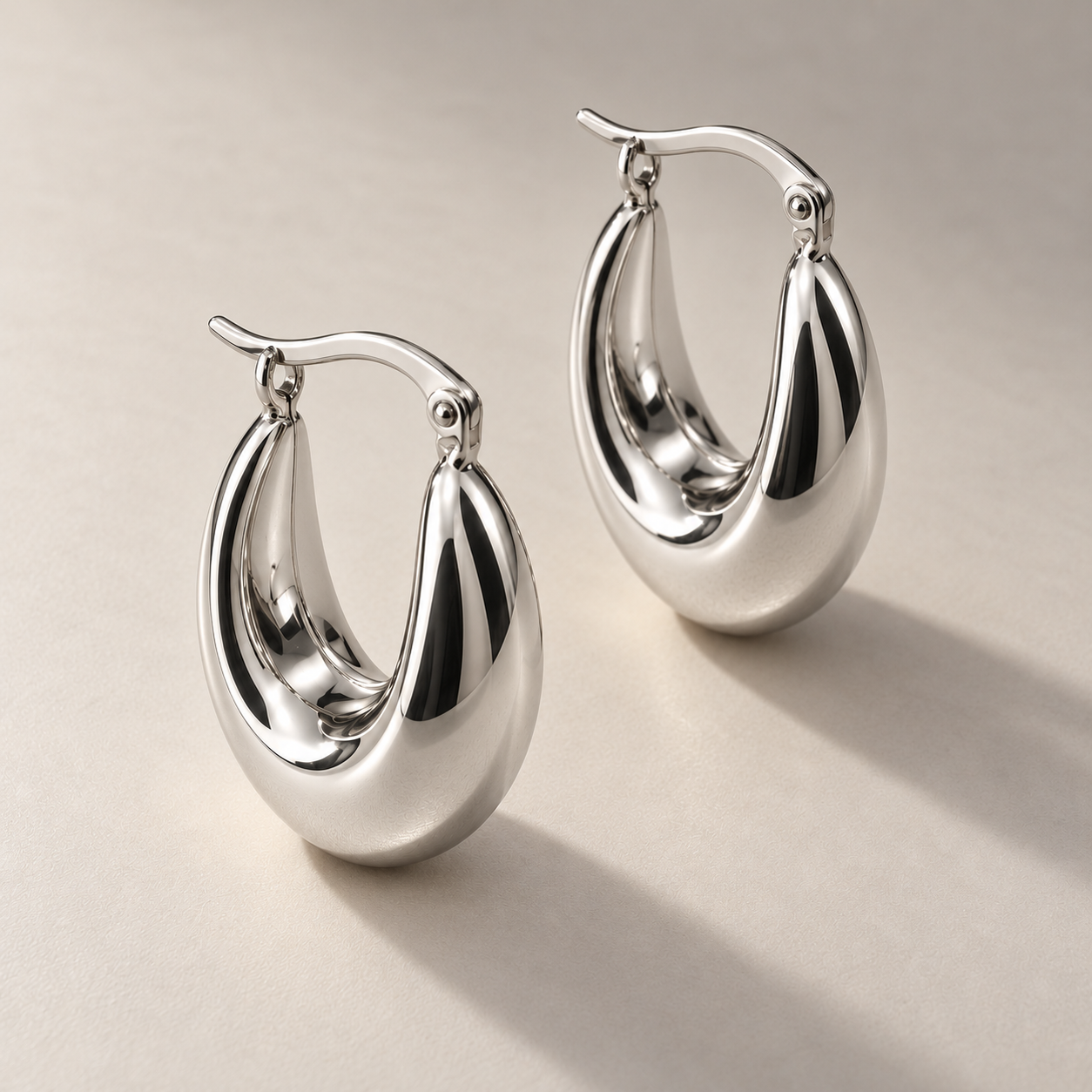 Polished white gold crescent hoop earrings.png